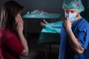 A surgeon giving unfortunate news to a victim's spouse.