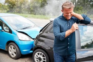 Middle-aged driver suffering neck pain from car accident.