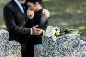 Lady crying at the funeral of her mother in the cemetery.