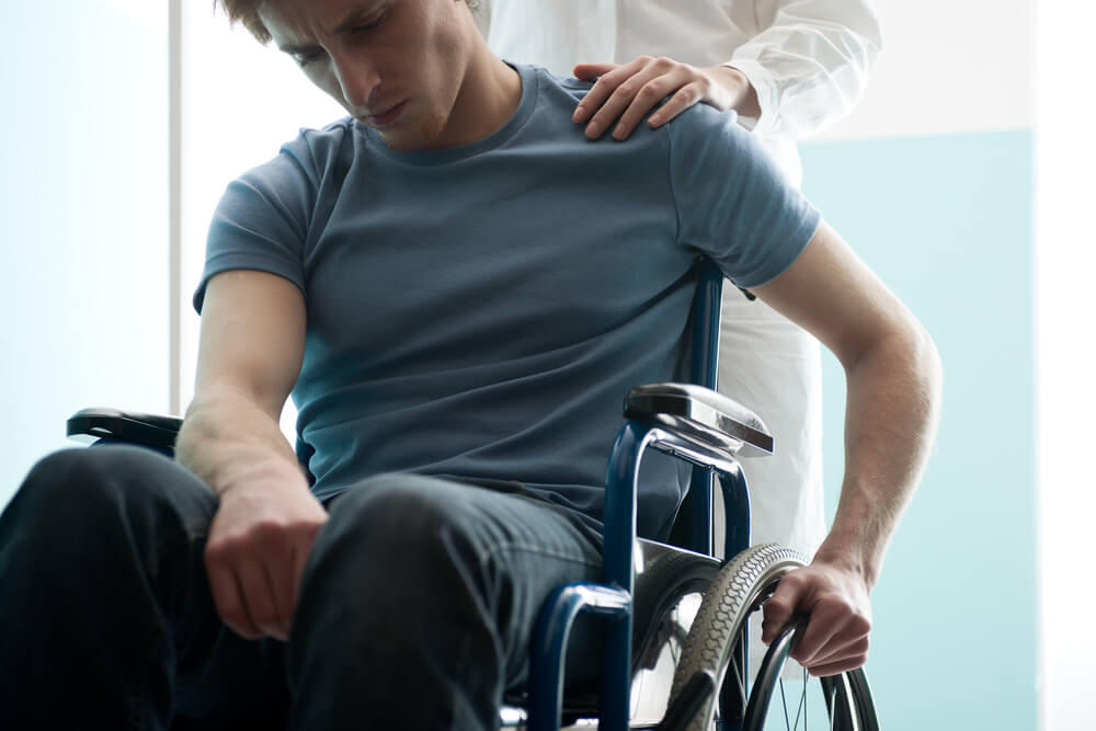 Sad man on a wheelchair suffering injuries from car accident.