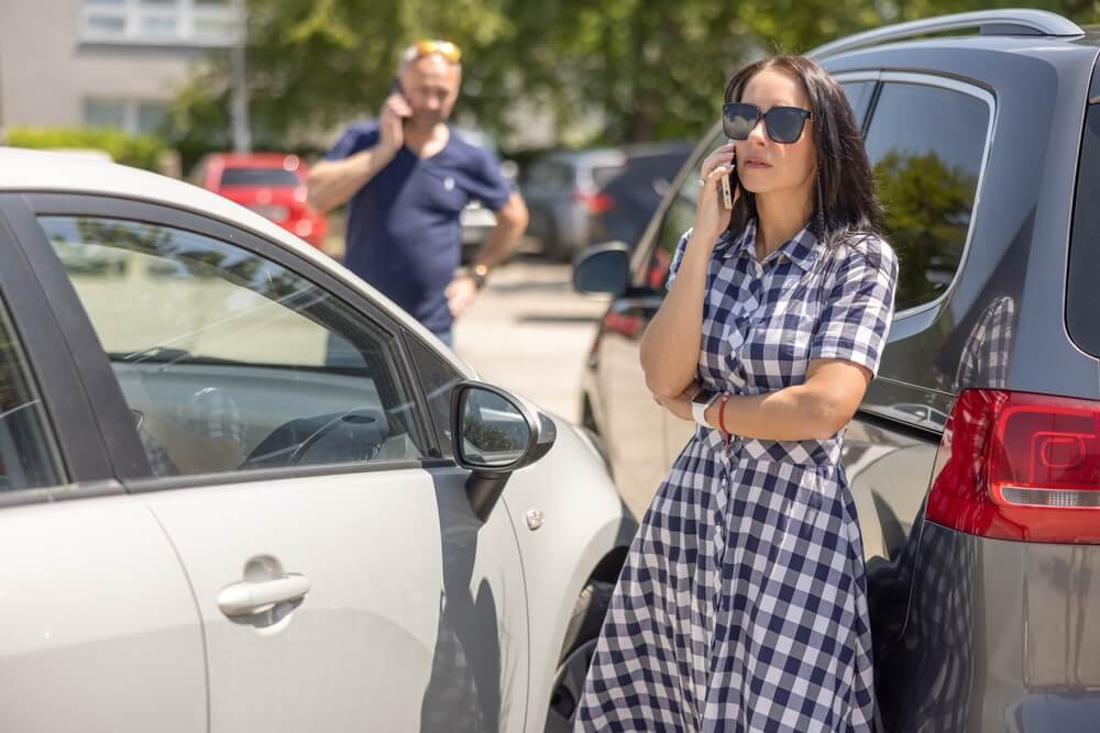 Lady driver calling insurance to report accident.