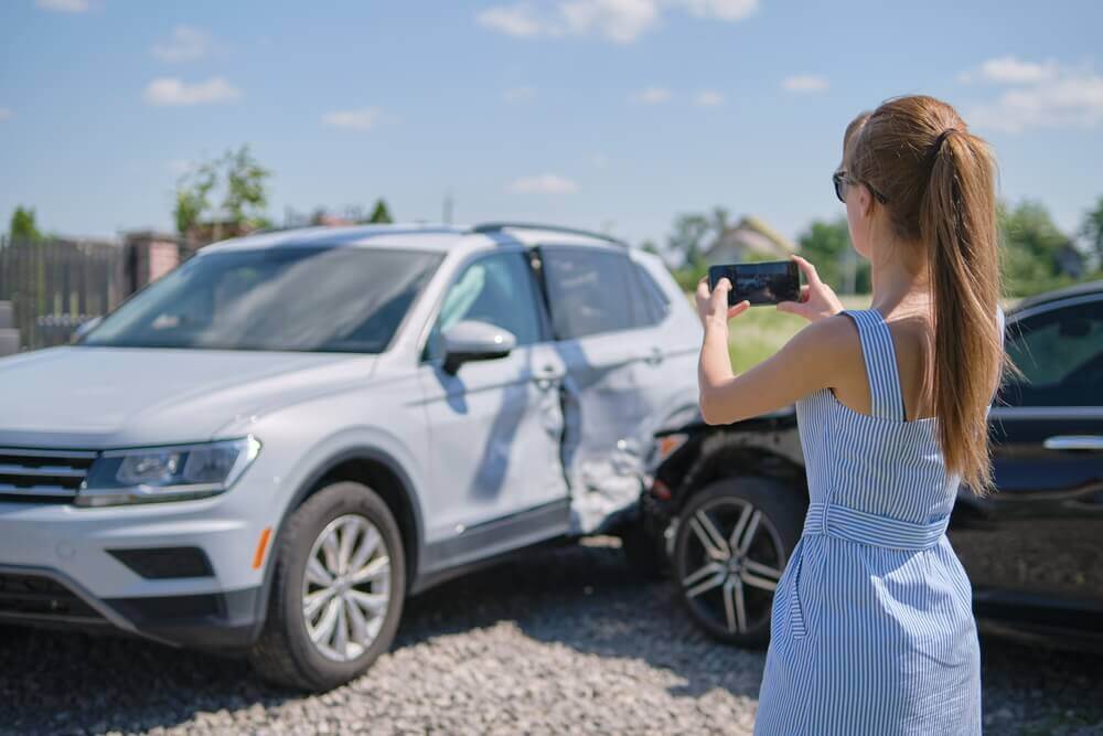 Lady driver taking photo on the car accident.