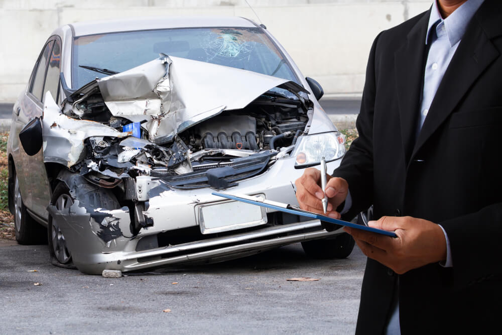 Insurance agent checking car accident damages.